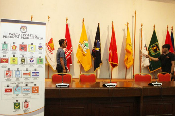 Petugas merapihkan bendera peserta partai politik 2019 di ruangan pendaftaran caleg di Gedung KPU, Jakarta, Selasa (3/7). (Foto: Antara Foto)