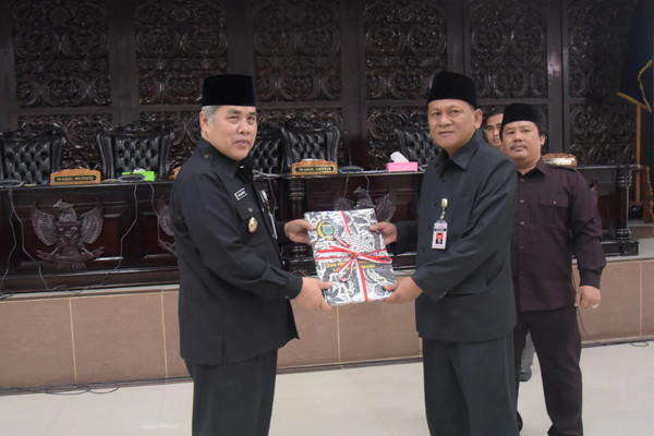 Wakil Bupati Kebumen, Yazid Mahfudz (kiri), menyerahkan tiga rancangan peraturan daerah (raperda) ke Ketua DPRD Kebumen, Cipto Waluyo (kanan), saat Rapat Paripurna DPRD, 18 Januari 2018. (Foto: kebumenkab.go.id)