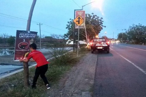 Kader PDIP mencopot spanduk "raja Jokowi" di ruas jalan di Kabupaten Demak, Jateng. (Foto: Ist)