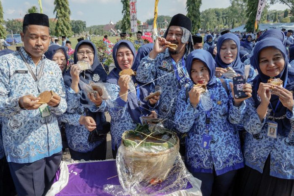Sejumlah ASN Kabupaten Pekalongan, Jateng, menyantap apem sela peringatan HUT ke-47 Korpri di Alun-alun Kajen, Kamis (29/11). (Foto: Antara Foto/Harviyan PP)
