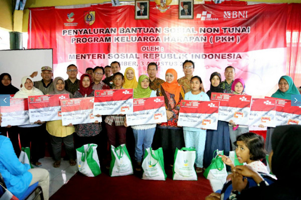 Khofifah Indar Parawansa (hijab oranye), menyalurkan bantuan PKH di Kabupaten Jember, Jawa Timur, 3 Agustus 2017. (Foto: Kemensos)