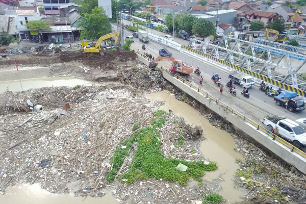 Alat berat mengeruk sampah Sungai Banjir Kanal Timur (BKT) dari jembatan Kaligawe, Kota Semarang, Jateng. (Foto: Twitter/@ganjarpranowo)