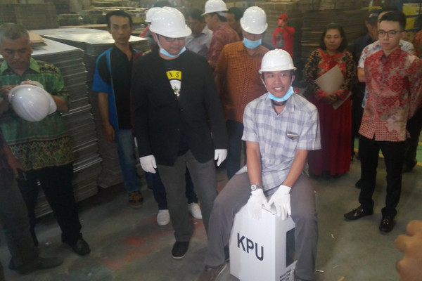 Komisioner KPU RI mencoba kekuatan kotak suara berbahan dupleks saat meninjau Pergudangan Sentra Kosambi, Tangerang, Banteng, Minggu (30/9). (Foto: Twitter/@KPU_ID)