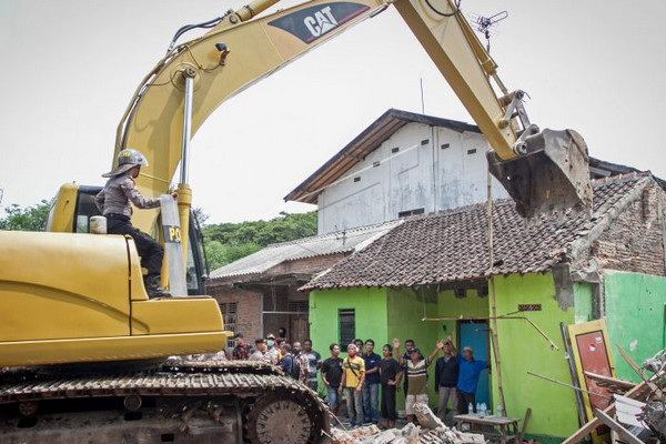 Sejumlah warga berusaha menghalangi ekskavator merubuhkan sebuah rumah kala mengeksekusi lahan di Kentingan Baru, Surakarta, Jateng, Kamis (6/12). (Foto: Antara Foto/M. Ayudha)