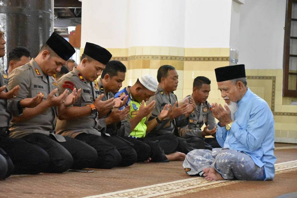  Personel Polres Demak berdoa bersama dipimpin KH M. Asyiq usai salat gaib untuk korban tsunami Selat Sunda di Masjid Agung Demak, Selasa (25/12). (Foto: Facebook/Humas Polres Demak)