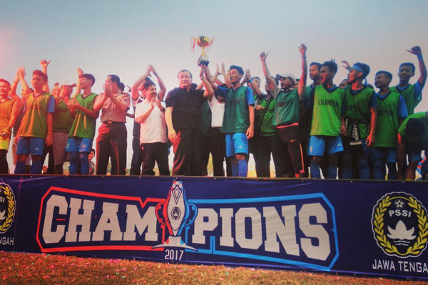 Ketua Asprov PSSI Jateng, Johar Lin Eng (kemeja hitam), menyerahkan trofi kepada kapten Persiku Junior. (Foto: Twitter/@pssi_jawatengah)