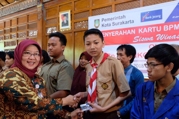 Kadisdik Surakarta, Etty Retnowati (kiri), secara simbolis menyerahkan kartu BPMKS di Pendhapi Gede Balai Kota, 16 November 2018. (Foto: Pemkot Surakarta)