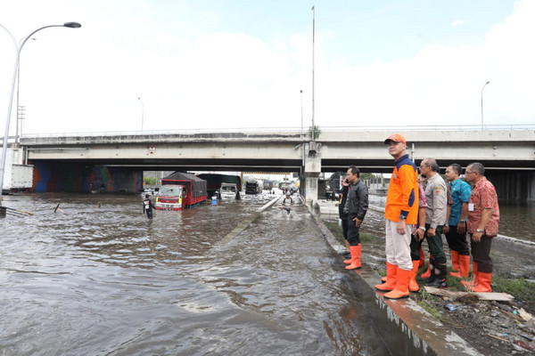 Gubernur Jateng, Ganjar Pranowo, mGubernur Jateng, Ganjar Pranowo (memakai topi), meninjau lokasi banjir di bawah jembatang tol Kaligawe, Kota Semarang, Selasa (4/12). (Foto: Pemprov Jateng)