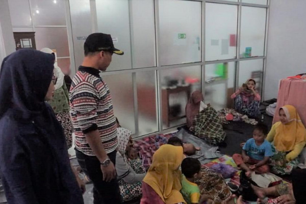 Bupati Batang, Wihaji (topi), saat meninjau korban banjir di posko pengungsian di Kantor PMI Batang, Jateng, Minggu (27/1) malam. (Foto: Pemkab Batang)