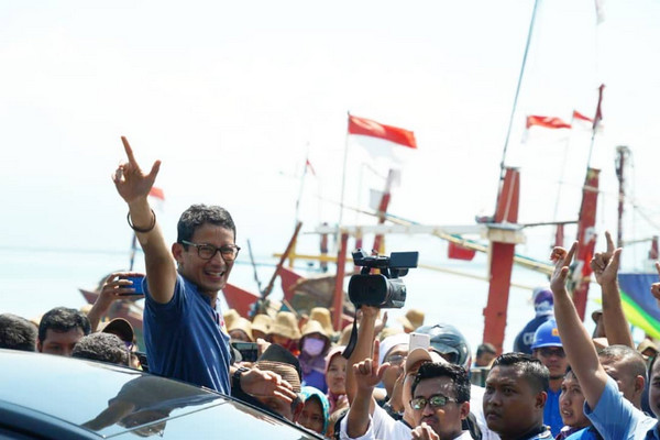 Cawapres nomor urut 02, Sandiaga Uno (kaos biru), mengacungkan salam dua jari saat berkampanye di Tempat Pelelangan Ikan (TPI) Tasikagung, Kabupaten Rembang, Jateng, Rabu (30/1). (Foto: Twitter/@sandiuno)