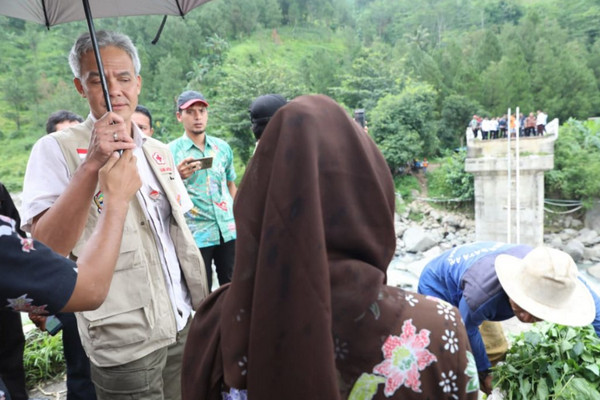 Gubernur Jateng, Ganjar Pranowo (mengenakan payung), saat meninjau Jembatan Kali Keruh di Desa Loragung, Kacamatan Kandangserang, Kabupaten Pekalongan, Rabu (30/1). (Foto: Pemprov Jateng)