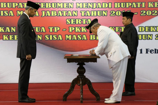 Gubernur Jateng, Ganjar Pranowo (Kiri), menyaksikan Bupati Kebumen, Yazid Mahfudz, menandatangani dokumen usai dilantik sebagai kepala daerah di Kota Semarang, Jumat (1/2). (Foto: Twitter/@kominfo_jtg)