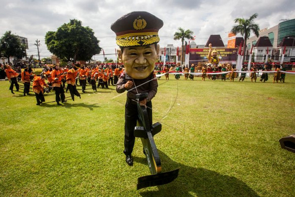 Seorang polisi mengenakan topeng wajah Kapolri, Jenderal Pol Tito Karnavian, saat pengukuhan kenaikan Polda DIY menjadi tipe A di Mapolda DIY, 7 Desember 2018. (Foto: Antara Foto/Andreas FA)