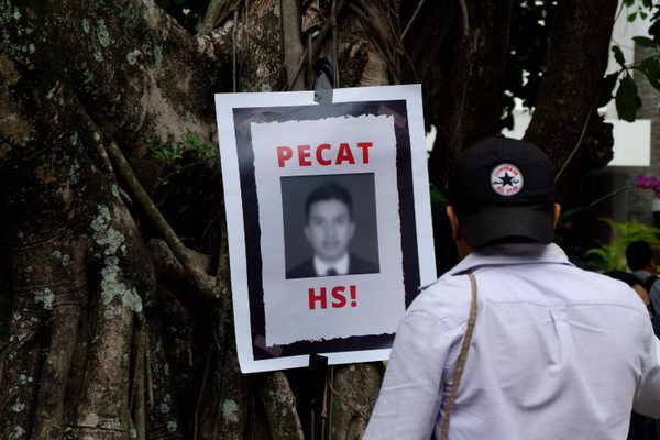 Seorang pria melihat poster berisi tuntutan pemecahan terduga pelaku pemerkosa Agni, HS, sebagai mahasiswa Fakultas Teknik UGM. (Foto: Rhetor/Bachri)