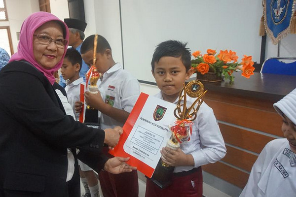 Kepala Disdik Surakarta, Etty Retnowati (kiri), saat menyerahkan piala lomba Mapsi SD/MI 2018 kepada pemenang. (Foto: Pemkot Surakarta)