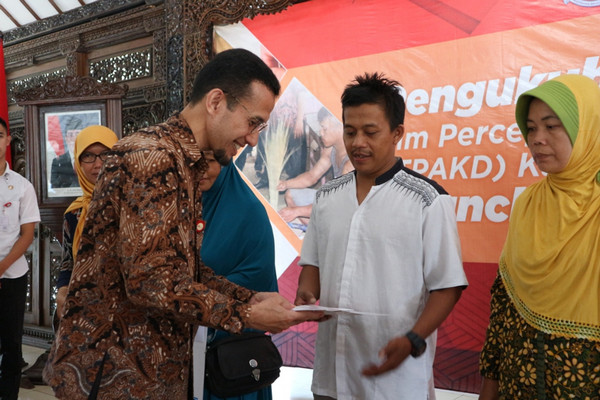 Deputi Direktur Manajemen Strategis, Edukasi dan Perlindungan Konsumen, dan Kemitraan Pemda OJK Jateng-DIY, Dedy Patria (batik cokelat), menyerahkan Kredit Mawar kepada salah satu pelaku UMKM di Pendopo Dipokusumo, Kabupaten Purbalingga, Jateng, Rabu (27/2). (Foto: Pemkab Purbalingga)