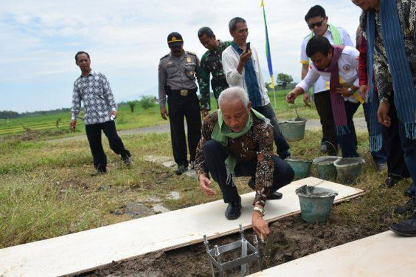 Bupati Sleman, Sri Purnomo (batik), saat peletakan batu pertama pembangunan PJUTS di Desa Sumberarum, Kecamatan Moyudan, Kabupaten Sleman, DIY, Jumat (8/3). (Foto: Pemkab Sleman)