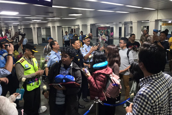 Petugas gabungan memberikan bunga kepada WNA yang baru tiba di Bandara Soekarno-Hatta, Banten, 1 Januari 2018. (Foto: Dok. TPI Soetta)