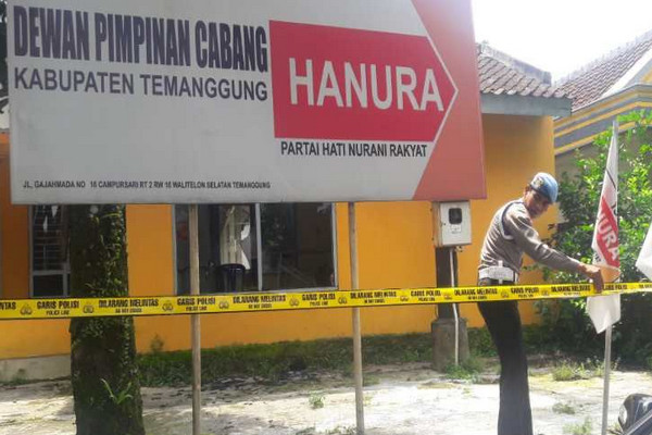 Aparat berwenang memasang garis polisi di halaman Kantor DPC Hanura Temanggung, Jalan Gajah Mada, Kabupaten Temanggung, Jateng, Kamis (21/3). (Foto: Antara/Heru Suyitno)