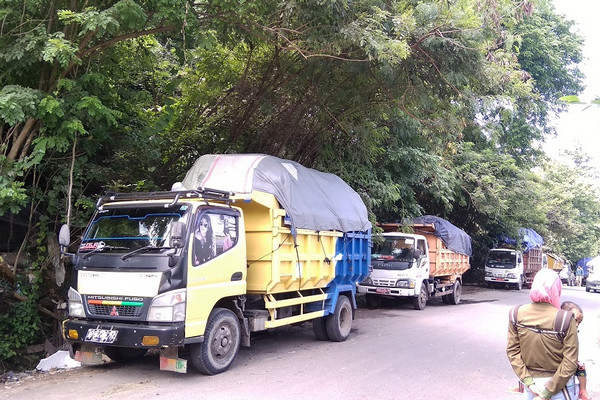 Sejumlah truk pengakut sampah parkir sebelum masuk Kompleks TPST Piyungan, Kabupaten Bantul, DIY, karena warga sekitar memblokir jalan, 31 Desember 2018. (Foto: Medcom/A. Mustaqim)
