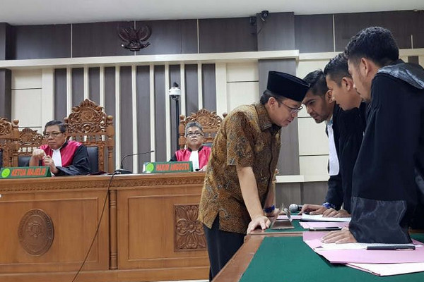 Terdakwa kasus dugaan suap DAK Kebumen-Purbalingga, Taufik Kurniawan (batik cokelat), berkonsultasi dengan penasihat hukumnya kala sidang di Pengadilan Tipikor Semarang, Jateng, Rabu (20/3). (Foto: Antara/IC Senjaya)