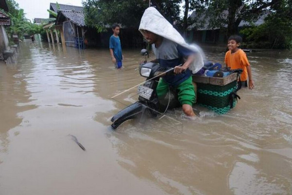 Pengendara motor menerjang banjir di Kecamatan Cawas, Kabupaten Klaten, Jateng, Kamis (7/3). (Foto: Antara Foto/Aloysius JN)