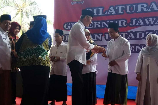 Gubernur Jateng, Ganjar Pranowo (tengah), secara simbolis menyerahkan insentif kepada perwakilan guru keagamaan di Pondok Pesantren Al Fiel, Kabupaten Cilacap, Jateng, Senin (8/4). (Foto: Antara/Sumarwoto)