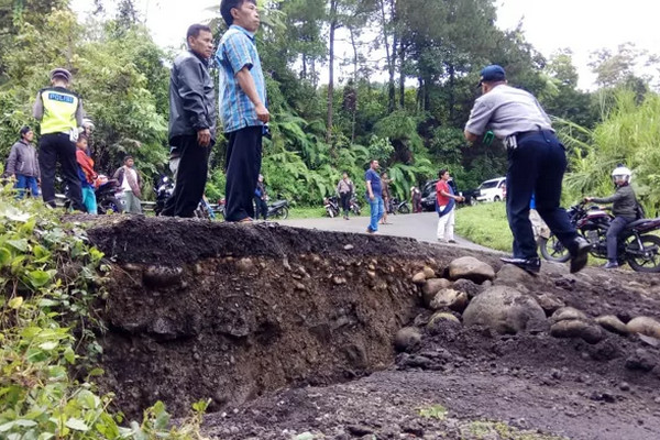 Petugas berjaga di lokasi amblesnya Jalan Raya Paninggaran, Kabupaten Pekalongan, Jateng, Selasa (22/1). (Foto: Radar Pekalongan/M. Hadiyan)