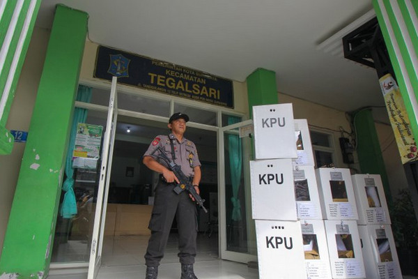 Polisi bersenjata laras panjang berjaga di lokasi rekapitulasi suara Pemiu 2019 di Kantor Kecamatan Tegalsari, Kota Surabaya, Jatim, Sabtu (20/4). (Foto: Antara Foto/Didik Suhartono)