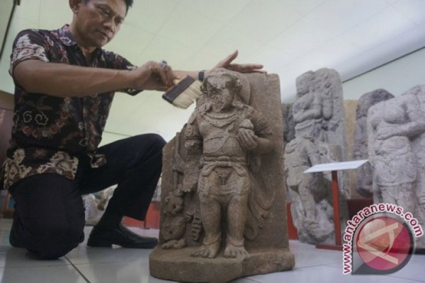 Petugas BPCB Trowulan membersihkan arca Nandiswara di Museum Wajakensis, Kabupaten Tulungagung, Jatim, Kamis (8/3). (Foto: Antara/Destyan Sujarwoko)