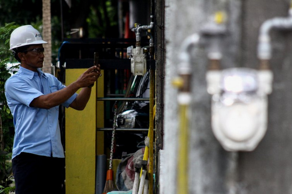 Petugas memeriksa meteran pipa jaringan gas di salah satu rumah warga yang telah mengunakan jaringan gas. (Foto: Antara Foto/Umarul Faruq)