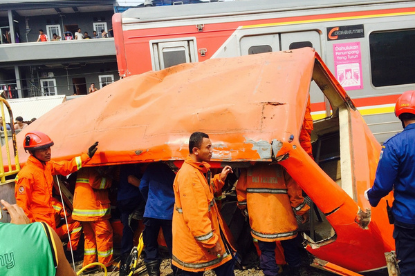 Petugas gabungan mengevakuasi bus kota yang ringsek tertabrak kereta api karena menerobos palang di Jakarta. (Foto: Twitter/@TMCPoldaMetro)