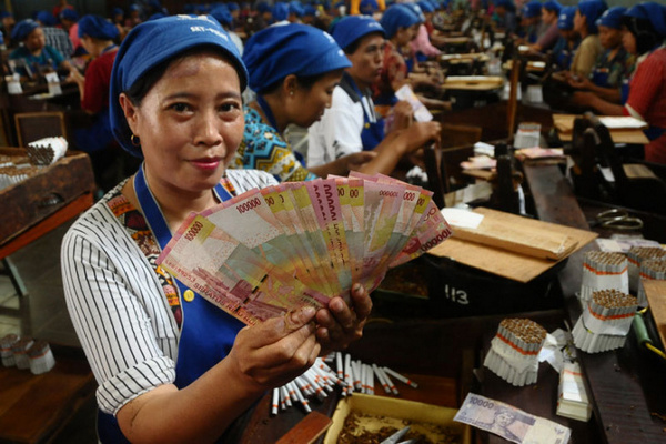 Pekerja pabrik menunjukkan uang THR Lebaran di tempatnya bekerja, Kabupaten Kudus, Jateng, 5 Juni 2018. (Foto: Antara Foto/Yusuf Nugroho)