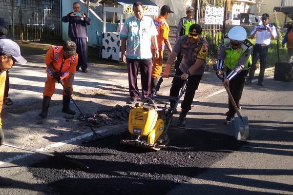 Kapolres Salatiga AKBP Gatot Hendro Hartono, tengah mengaspal di salah satu ruas jalan Kota Salatiga, Jateng, Kamis (9/5). (Foto: Polres Salatiga)