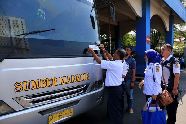 Kepala Dishub Jateng, Satriyo Hidayat (kiri), menempeli striker di kaca depan bus AKDP yang laik beroperasi di Terminal Tirtonadi, Kota Surakarta, Jateng, Senin (13/5). (Foto: Pemprov Jateng)