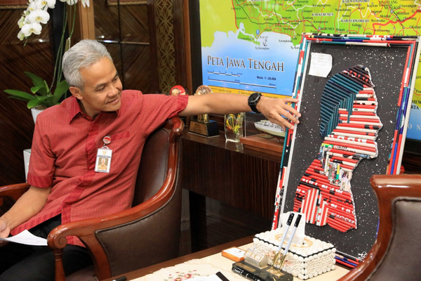 Gubernur Jateng, Ganjar Pranowo, memegang lukisan berupa siluet wajah dirinya di ruang kerjanya, kompleks Kantor Gubernur Jateng, Kota Semarang, Selasa (14/5). (Foto: Pemprov Jateng)