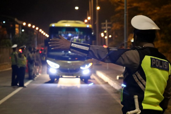 Polisi menghentikan bus untuk diperiksa di akses keluar Jembatan Suramadu, Kota Surabaya, Jatim, Minggu (19/5) dini hari. (Foto: Antara Foto/Didik Suhartono)