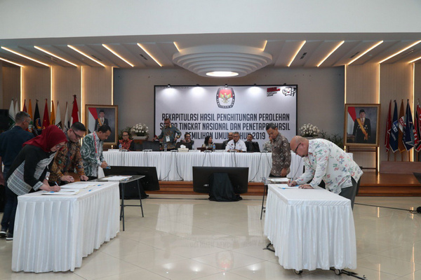 Sejumlah komisioner KPU menandatangani dokumen hasil rekapitulasi suara Pemilu 2019 sela rapat pleno di kantor KPU, Jakarta, Selasa (21/5) dini hari. (Foto: Twitter/@KPU_ID)
