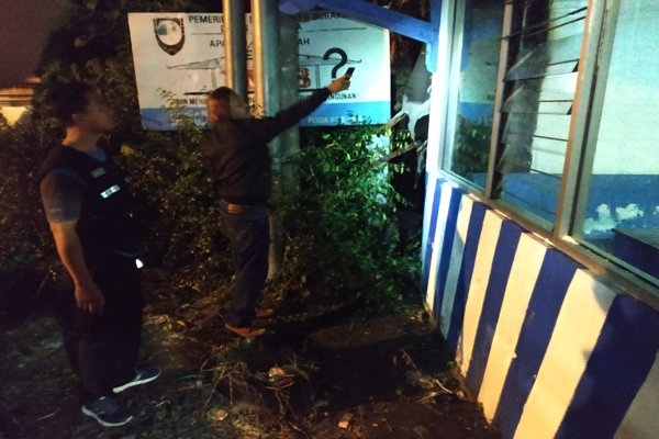 Salah seorang saksi, Ahmad Arifin, menunjukkan lokasi asal mula api di Pospol Fajar Indah, Kota Surakarta, Jateng, Jumat (24/5) dini hari. (Foto: Solopos/Ichsan Kholif Rahman)