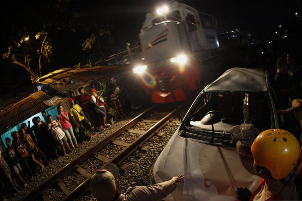 Petugas mengevakuasi mobil yang terlibat kecelakaan dengan KA Jayakarta di perlintasan sebidang di Purwosari, Kota Surakarta, Jateng, Senin (20/5). (Foto: Antara Foto/Maulana Surya)