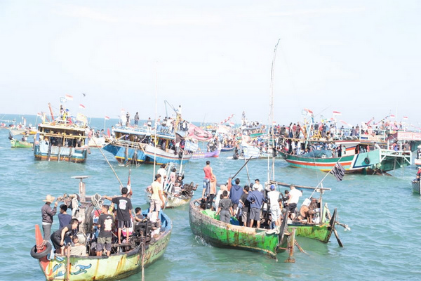Para nelayan menggunakan perahu tengah berebut sesaji yang dilarung ke laut saat Pesta Lomban di perairan Kabupaten Jepara, Jateng, Rabu (12/6). (Foto: Twitter/@zainuddinpoten)