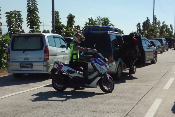 Petugas meminta pengendara tak berhenti ruas Tol Cikopo-Palimanan, Jabar. (Foto: Antara/Budi Santoso)