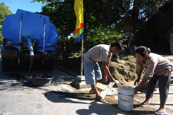 Pekerja mengisi bak penampungan air warga di lereng Gunung Merapi, Desa Cluntang, Kecamatan Musuk, Kabupaten Boyolali, Jateng, Rabu (12/6). (Foto: Antara Foto/Aloysius Jarot Nugroho) 