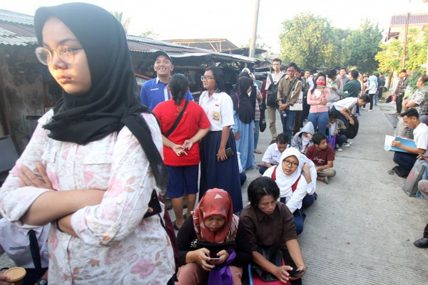 Sejumlah calon siswa dan orang tua mengantre saat akan mengikuti seleksi PPDB di SMAN 1 Depok, Kota Depok, Jabar, Selasa (18/6). (Foto: Antara Foto/Yulius Satria Wijaya)