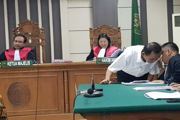 Bekas Kepala Disdik Kendal, Muryono (kemeja putih), berkonsultasi dengan penasihat hukumnya sela sidang di Pengadilan Tipikor Semarang, Jateng, Senin (1/7). (Foto: Antara/IC Senjaya)