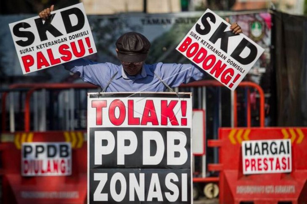 Seorang pria menggelar demo tolak sistem zonasi PPDB di Kota Surakarta, Jateng, Selasa (2/7). (Foto: Antara Foto/Mohammad Ayudha)