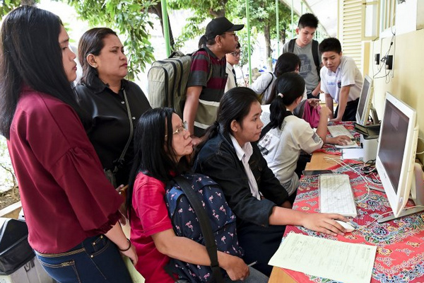 Sejumlah siswa dan orang tua murid mendaftar PPDB menggunakan komputer di SMAN 1 Jakarta, Jakarta, Senin (24/6). (Foto: Antara Foto/Galih Pradipta)