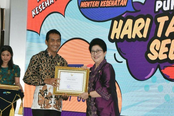 Menkes, Nila Moeloek (kanan), menyerahkan penghargaan Prastika Parama kepada Wakil Bupati Batang, Suyono, sela peringatan HTTS di Jakarta, Kamis (11/7). (Foto: Pemkab Batang)