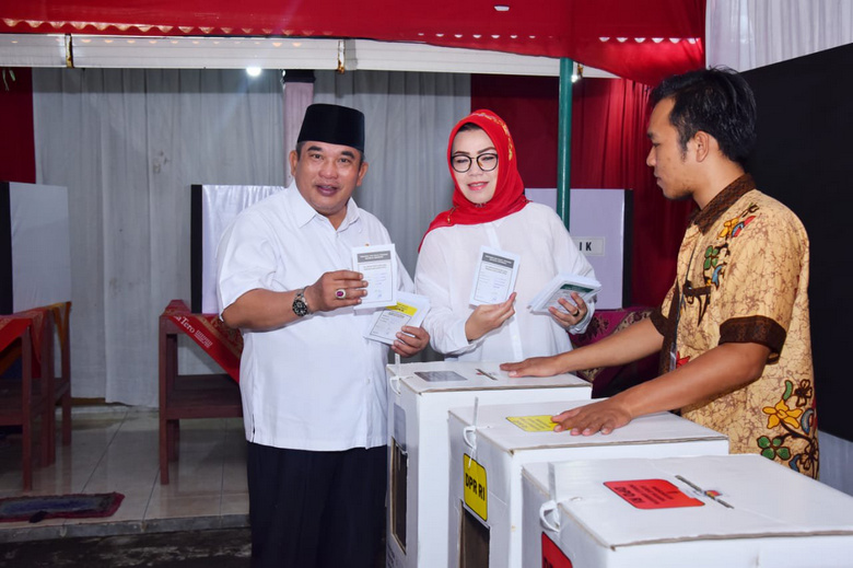 Istri Bupati Sukoharjo, Etik Suryani (tengah), ditemani suaminya (kiri) sela pemungutan suara Pemilu 2019 di TPS 03 Kampung Larangan, Desa Gayam, Kecamatan/Kabupaten Sukoharjo, Jateng, Rabu (17/4). (Foto: Twitter/@sukoharjo_kab)