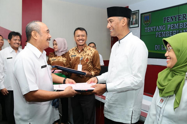 Bupati Kudus, M. Tamzil (berpeci), memberikan SK pensiun kepada seorang PNS pemkab di Kabupaten Kudus, Jateng, Kamis (25/7). (Foto: Pemkab Kudus)